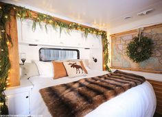 a bed in a room with christmas decorations on the headboard and lights hanging from the ceiling