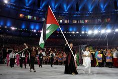 a group of people standing on top of a stage holding flags