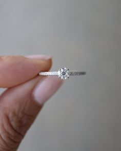 a person holding a diamond ring in their hand