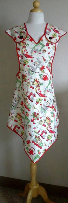 a mannequin wearing a white dress with red trim and cartoon characters on it