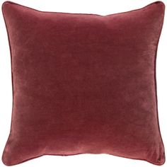 a dark red velvet pillow on a white background