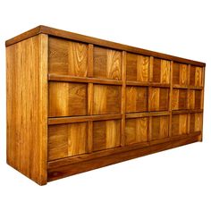 a wooden bookcase with many compartments on the top and bottom, against a white background