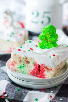 a piece of cake with white frosting and sprinkles sitting on plates