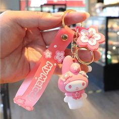 someone is holding up a hello kitty keychain