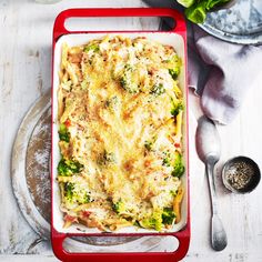 a casserole dish with broccoli, cheese and other toppings on a table