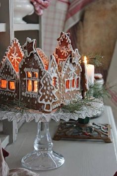 gingerbread houses lit up with candles on a table