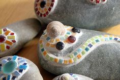 some rocks with colorful designs on them sitting on a wooden table next to each other