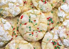 a plate full of cookies with sprinkles and powdered sugar on top