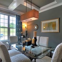 a dining room table with white chairs and a chandelier