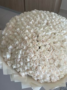 a large bouquet of white roses sitting on top of a table