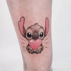 a tattoo on the leg of a person with a pink heart in it's mouth