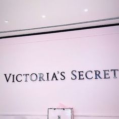 the victoria's secret sign is displayed in front of a pink wall with black lettering