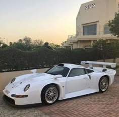 a white sports car parked in front of a house