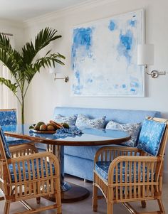 a living room filled with furniture and a painting on the wall above it's table