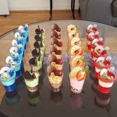 an assortment of desserts are arranged on a glass table in front of a couch