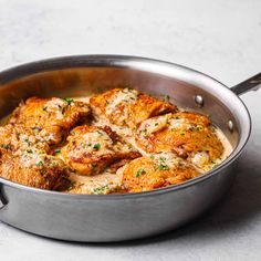 a pan filled with chicken and sauce on top of a table