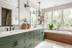 a large bathroom with green cabinets and white walls