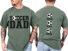 Celebrate your favorite soccer player with our custom soccer dad shirt, personalized with the players names on back. With short sleeves and a classic crewneck, this shirt makes the perfect gift for the soccer father who loves to show his support on game day at the soccer fields, making him feel like a varsity soccer super fan. COMFORT COLORS 1717 SHIRT: Unisex 100% US cotton - ethically grown and harvested Pre-Shrunk Fabric Relaxed Fit - Size up for a trendy oversized look Seamless Sides Double Personalized Crew Neck T-shirt For Fans, Personalized Fan Merchandise Crew Neck T-shirt, Personalized Sporty T-shirt For Sports, Sporty Personalized T-shirt For Sports Events, Sporty Personalized T-shirt For Sports, Personalized Crew Neck T-shirt For Game Day, Personalized Short Sleeve Tops For Sports Events, Personalized Crew Neck Sports Top, Soccer Dad Shirt