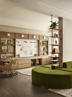 a living room filled with furniture and bookshelves next to a wall mounted whiteboard