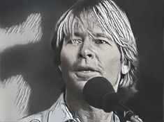 a black and white photo of a person holding a microphone