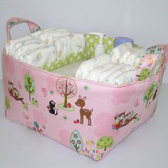 a pink baby diaper caddy with animals and trees on it