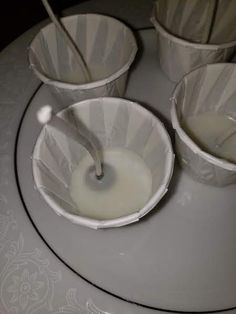 three buckets filled with milk sitting on top of a table