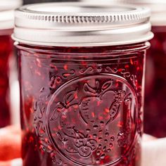 jars filled with red liquid sitting on top of a table