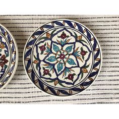 two plates sitting on top of a table next to each other with designs on them