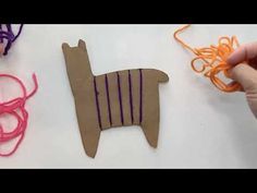 someone is making a llama out of paper and yarn