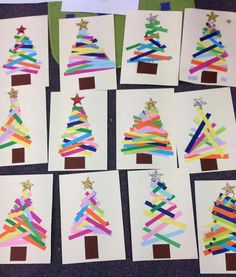 christmas tree made out of strips of colored paper on top of a table next to other cards