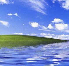 an island in the middle of water under a blue sky with clouds