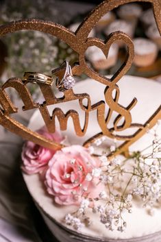 a wedding cake with two hearts and the word mr and mrs on it, surrounded by flowers