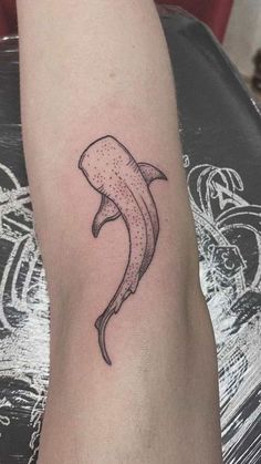 a black and white photo of a banana tattoo on the left arm with dots in it