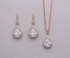 "Add brilliant sparkle with these classically designed framed cubic zirconia teardrop wedding earrings. Measuring 1 1/4\" long, these are perfect for any special occasion. Earrings feature a CZ encrusted French hook with a dangling teardrop for a truly unique look! Can be ordered in gold and rose gold as well. Can be made with a matching teardrop pendant necklace measuring 16 1/2\" long with an additional 2\" extender. All jewelry features high quality electroplating that does not fade or chip a Rose Gold Teardrop Cubic Zirconia Earrings, Rose Gold Cubic Zirconia Teardrop Earrings, Pear-shaped Teardrop Earrings With Diamond Accents For Wedding, Wedding Teardrop Earrings With Diamond Accents, Classic Teardrop Cubic Zirconia Earrings, Elegant Teardrop Drop Earrings In Cubic Zirconia, Classic Teardrop Earrings With Cubic Zirconia Pendant, Classic Teardrop Earrings With Cubic Zirconia, Classic Cubic Zirconia Teardrop Earrings