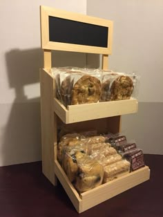 three tiered display case filled with different types of pastries and chocolates in front of a white wall