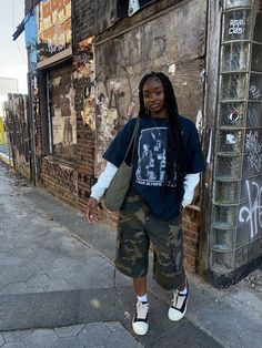 a woman standing in front of a building with graffiti on it