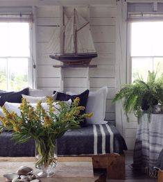 a living room filled with lots of furniture and flowers in a vase on top of a table