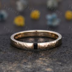 a wedding band with a black diamond in the middle