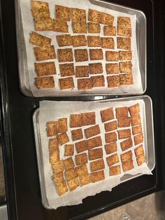 two trays filled with crackers sitting on top of a counter next to each other