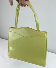 Circa: 1950s 1960s A rare and most stunning colour! Chartreuse vinyl medium handbag by Lennox. The colour bold and lovely and the closure is spring locked with a little coin purse of rayon to match the interior. Exceptional condition. Why was she not used more than once if at all? They'll think you've loads of money with this sort of stylish handbag DO YOU ACCEPT OFFERS? We do NOT accept offers or negotiate on pricing. We do offer layaways and have sales throughout the year. Shipping overages ar Air Pillow, Faux Leather Handbag, Medium Handbags, Vintage Inspired Dresses, Handbag Purse, Banking, Clutch Handbag, Leather Handbag, Vintage 1950s