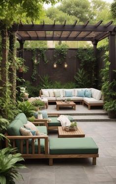 an outdoor seating area with couches, tables and plants