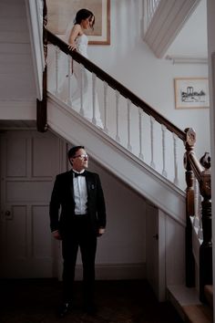 a man in a tuxedo is standing on the stairs