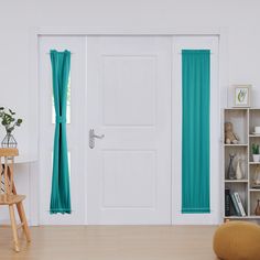 a white door with blue curtains and a wooden chair in front of it on a hard wood floor