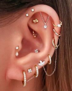 a woman wearing ear piercings with different designs