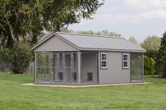 a dog kennel in the middle of a grassy field