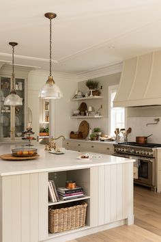 a man standing in the middle of a kitchen with lots of counter space and stools