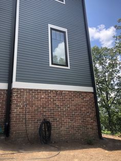 a hose is attached to the side of a building with a window on it's side