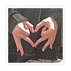 two hands in the shape of a heart with their fingers touching each other's chests