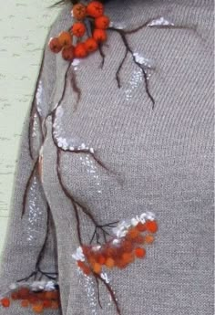 an embroidered sweater with orange flowers on the front and back, along with sequins