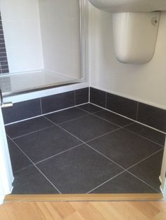 a bathroom with black and white tiles on the floor